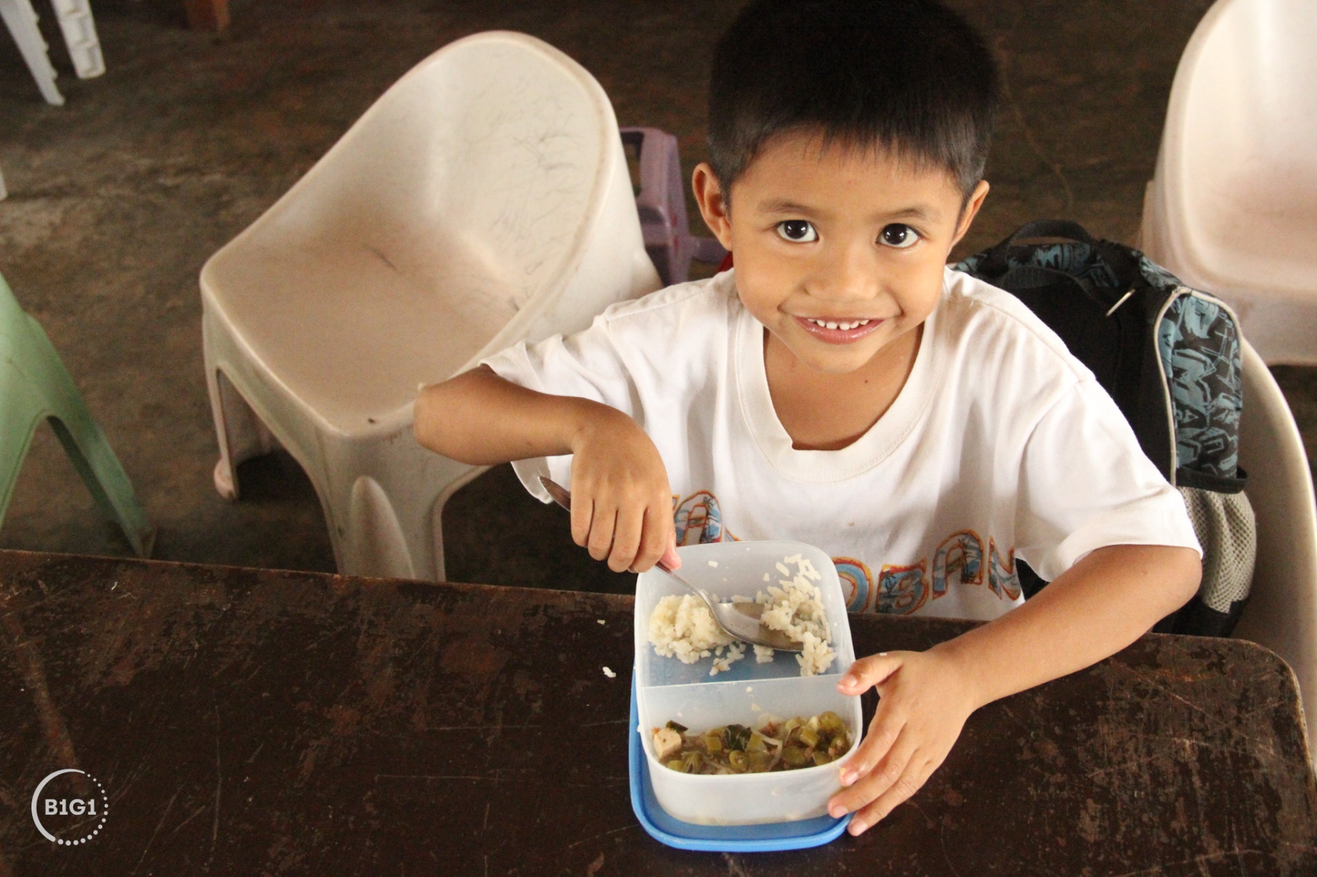 Child receiving a hot meal at a B1G1 partner project